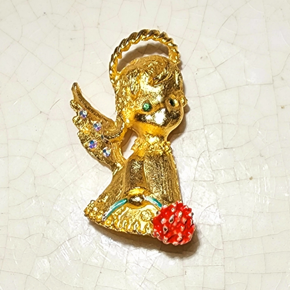 MYU gold angel with emerald colored eyes holding a daisy